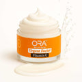 ORA Vitamin C Instant Glow Facial Cream in jar with splashes, brightening moisturizer for radiant skin.